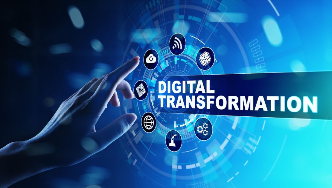 Hand reaching toward a digital interface with icons representing cloud computing, IoT, automation, and connectivity, surrounding the words “Digital Transformation” on a futuristic blue background.
