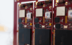 Close-up of red printed circuit boards with chips and connectors arranged in rows, showing fine electronic details.